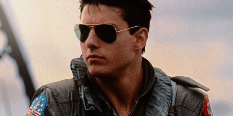 A imagem mostra Tom cruise durante as gravações de Top Gun 1 com seu macacão de aviador.